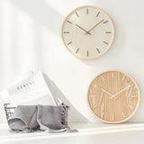 Mise en situation de deux horloges murales en bois naturel clair et foncé, design nordique pour une décoration intérieure tendance.