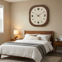 Grande horloge murale carrée design suspendue au-dessus d'un lit double dans une chambre à coucher de style mid-century