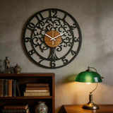 Horloge murale moderne Arbre de Vie en métal noir sur fond de mur texturé avec lampe verte de style rétro