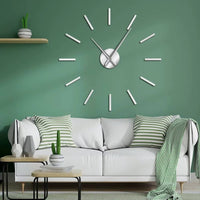 Horloge murale 3D sticker DIY argentée au design minimaliste et scandinave fixée sur un mur vert au-dessus d'un canapé blanc.