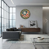 horloge murale américaine au design vintage accrochée bien en vue sur le mur gris d'un salon moderne. L'horloge ronde se distingue par son cadran effet bois patiné affichant le drapeau des États-Unis et le célèbre panneau de la Route 66, créant un contraste saisissant avec l'aménagement contemporain et urbain de la pièce.
