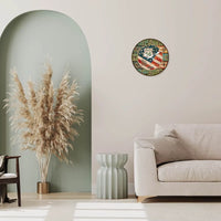 horloge murale américaine ronde au design vintage, affichant le drapeau des États-Unis et le logo de la "Route 66". En dessous, un long bahut en bois flottant abrite des livres et un vase rempli d'herbes de la pampa. À droite, un fauteuil en rotin avec un coussin crème et une couverture ethnique crée un espace de détente confortable. L'ensemble est complété par des tables basses gigognes en bois clair et un tapis en jute au sol.