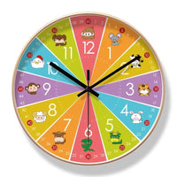 Horloge murale pour enfant de 30 cm avec un cadran coloré entouré de 12 animaux différents, dont une souris, une vache, un lion, un serpent, une chèvre et un mouton. Son design ludique et multicolore est idéal pour décorer une chambre d’enfant.