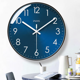 Horloge murale bleue au cadran bleu profond avec douze chiffres blancs et trois aiguilles blanches. Son contour noir souligne son allure contemporaine. Cette horloge au style moderne et épuré convient à une décoration minimaliste dans le salon.