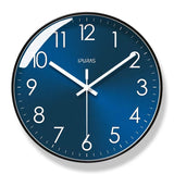 Horloge murale bleue au cadran bleu profond avec douze chiffres blancs et trois aiguilles blanches. Son contour noir souligne son allure contemporaine. Cette horloge au style moderne et épuré convient à une décoration minimaliste dans un salon, une chambre ou un bureau aux lignes sobres.