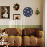 horloge murale bleue marine ancienne intégrée à une décoration murale vintage avec des fauteuils rétro confortables.