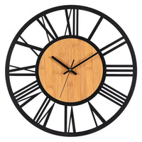 Cette horloge murale en bois et métal de 40 cm associe un style industriel et scandinave à une forme ronde et minimaliste chiffre romain sur fond blanc