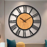 Cette horloge murale en bois et métal de 40 cm avec chiffres romains associe un style industriel et scandinave à une forme ronde et minimaliste, idéale pour le salon