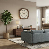Horloge murale carrée en bois accrochée dans un salon moderne et chaleureux avec canapé bleu et plante verte