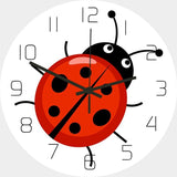 Horloge murale coccinelle rouge à pois noirs au centre d’un cadran blanc avec 12 chiffres, deux antennes et de grands yeux, idéale pour une chambre d’enfant mesurant 30 cm diamètre