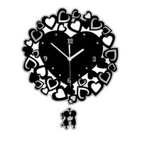 Horloge murale design noir avec un grand cœur central entouré de multiples petits cœurs et un balancier motif couple d'amoureux.