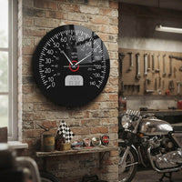Une horloge murale compteur de vitesse est installée sur un mur de briques apparentes dans un atelier de style industriel, entourée d'outils, d'objets de collection et d'une moto vintage.