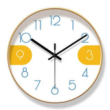 Horloge murale créative nordique avec cadran blanc, chiffres bleus et chiffres 3 et 9 sur fond jaune moutarde. Le cadre doré apporte une finition élégante à son design minimaliste et scandinave. Cette horloge moderne ajoute une touche chaleureuse et originale à un salon, une chambre, un bureau ou une entrée contemporaine.