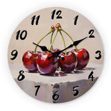 Horloge murale cuisine cerise représentant cinq cerises rouges éclatantes avec un effet peinturé artistique sur un cadran aux nuances beige clair et gris doux. Les fruits sont mis en valeur au centre de l’horloge avec des détails rappelant une illustration gourmande, tandis que les chiffres des heures noirs de tailles variées apportent du contraste au design. Une décoration murale fruitée et originale idéale pour une cuisine au style champêtre, rustique ou vintage