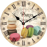 Horloge murale macarons colorés avec assortiment de pâtisseries aux saveurs pistache, fraise, chocolat, caramel, vanille et couleurs pastel.