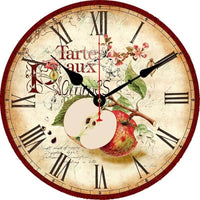 Horloge murale pomme au style vintage avec deux pommes rouges dont une coupée en deux. Le cadran présente des fleurs et l’inscription « Tarte aux pommes ». Les chiffres romains décorent le cadran vieilli. Le contour bordeaux foncé apporte une touche chaleureuse et élégante à cette décoration de cuisine.