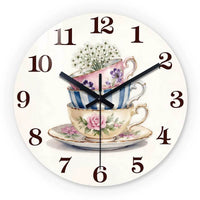 Horloge murale décorative représentant trois tasses de thé empilées aux couleurs rose bleu et blanc cassé avec des fleurs. tea cup floral.