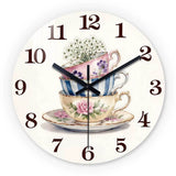Horloge murale décorative représentant trois tasses de thé empilées aux couleurs rose bleu et blanc cassé avec des fleurs. tea cup floral.