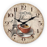 Horloge murale café Paris au style vintage représentant une tasse de café rétro avec l'inscription « Café Paris » sur le cadran. En arrière-plan, la Tour Eiffel apparaît délicatement accompagnée d'un magnifique papillon qui apporte une touche poétique à la décoration. Le fond beige clair du cadran renforce l'ambiance chaleureuse et authentique de cette horloge murale inspirée des cafés parisiens. Les deux aiguilles noires entourent les chiffres des heures pour une lecture facile tout en conservant un design