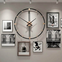 Grande horloge murale design salon en métal noir et bois suspendue au milieu d'un mur de cadres photos