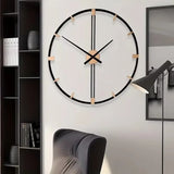 Horloge murale minimale dans le salon en métal noir avec aiguilles et repères dorés sur fond blanc.