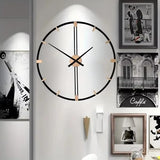 Horloge murale decorative salon noire et dorée intégrée dans une composition de cadres photos muraux.