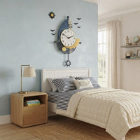 Horloge murale design et moderne bateau voilier suspendue au-dessus d'un lit dans une chambre d'enfant aux accents marins et côtiers