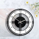 Horloge murale design contemporain noir et blanc à cadran ajouré géométrique de 30 cm sur le mur avec fleur 