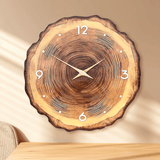 Horloge murale design en bois avec chiffres et aiguilles dorées posée sur fond chaleureux