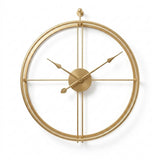 Horloge murale dorée design au style épuré, mise en valeur sur un fond blanc neutre et lumineux. Son cadran minimaliste à double cercles et son aiguille ornée d'une feuille apportent une note raffinée à votre décoration.