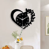 Horloge murale design en forme de cœur noir avec une silhouette d'envol de papillons sur le côté droit dans la salle