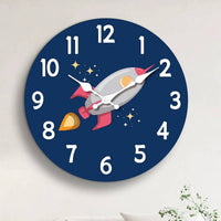 Horloge murale fusée spatiale installée dans une chambre d’enfant. La fusée grise et rouge bordeaux apporte une décoration originale sur le thème de l’espace. Le cadran bleu foncé avec ses étoiles crée une ambiance idéale pour les enfants passionnés par les fusées et les astronautes.