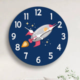 Horloge murale fusée spatiale installée dans une chambre d’enfant. La fusée grise et rouge bordeaux apporte une décoration originale sur le thème de l’espace. Le cadran bleu foncé avec ses étoiles crée une ambiance idéale pour les enfants passionnés par les fusées et les astronautes.