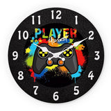 l'horloge murale gaming ronde "Player The Best" avec manette de jeu vidée fond noire et éclaboussures de peinture multicolores