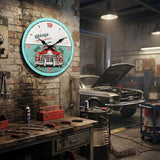 Horloge murale vintage Garage automobile "SERRURE & REPAIR" installée sur un mur de briques dans un garage ou atelier mécanique rétro, avec un établi rempli d'outils et une voiture ancienne en arrière-plan.