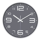 Une horloge murale grise contemporaine pour cuisine. Ce modèle arbore de grands chiffres numériques stylisés (12, 3, 6, 9 agrandis), des index en forme de bâtonnets blancs et un cadran gris foncé épuré.