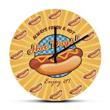 Horloge murale hot dog originale avec sandwich américain accompagné de ketchup et de moutarde. Le design gourmand rappelle la street food américaine et les célèbres stands de hot dogs. Une décoration murale originale idéale pour une cuisine et pour les passionnés de cuisine américaine et de spécialités gourmandes.