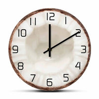 Horloge murale en forme de moitié de noix de coco avec une coque marron et un centre blanc rappelant la chair du fruit, décoration exotique.