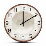 Horloge murale en forme de moitié de noix de coco avec une coque marron et un centre blanc rappelant la chair du fruit, décoration exotique.