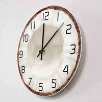 Horloge murale en forme de moitié de noix de coco avec une coque marron et un centre blanc rappelant la chair du fruit, décoration exotique.-side