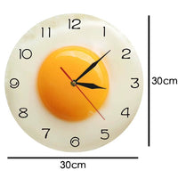 Horloge murale design œuf au plat de 30 cm avec dimensions affichées sur fond blanc