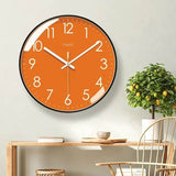 Horloge murale orange moderne avec cadran orange, contour noir, chiffres blancs et aiguilles blanches. Les minutes sont indiquées par des points blancs autour du cadran. Son design épuré et coloré convient parfaitement bureau -au salon, à la chambre ou à la cuisine pour apporter une touche chaleureuse et contemporaine