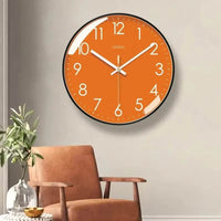 Horloge murale orange moderne avec cadran orange, contour noir, chiffres blancs et aiguilles blanches. Les minutes sont indiquées par des points blancs autour du cadran. Son design épuré et coloré convient parfaitement au salon, à la chambre ou à la cuisine pour apporter une touche chaleureuse et contemporaine dans le salon