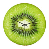 une horloge murale ronde au motif réaliste de tranche de kiwi. Le fond présente la chair verte acidulée et les petits pépins noirs du fruit, avec des chiffres blancs épurés et des aiguilles noires au centre