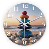 Horloge murale zen représentant cinq pierres naturelles empilées les unes sur les autres dans un équilibre parfait. Ce design inspiré des pierres zen évoque la sérénité, l’harmonie et la connexion avec la nature. Les différentes couleurs des pierres créent une composition douce et apaisante rappelant un paysage de plage calme avec une vue sur la mer. Cette horloge décorative apporte une ambiance relaxante dans un salon, une chambre ou un espace de méditation. Ses chiffres blancs et ses aiguilles élégantes p