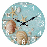 Horloge murale salle de bain décorée d'un magnifique décor marin avec plusieurs coquillages de différentes tailles et de délicates étoiles de mer. Son fond bleu clair rappelle les eaux cristallines de l'océan et crée une ambiance apaisante. Les chiffres blancs et les aiguilles noires assurent une lecture facile de l'heure tout en mettant en valeur le design. Disponible en 30, 35 et 40 cm de diamètre, cette horloge murale bord de mer est idéale pour une salle de bain, une salle d'eau ou un spa. 