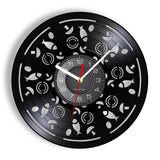 Horloge murale originale en vinyle avec des motifs d'ingrédients de pizza découpés. Le cadran central est entouré de poissons, champignons et olives sur le disque vinyle.