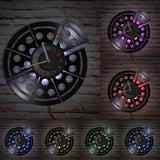Horloge murale en vinyle découpé en forme de pizza avec une part détachée. Son rétroéclairage LED multicolore éclaire le mur de briques de différentes nuances.