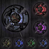 Avec LED - Horloge murale en vinyle noir représentant un skateur en plein saut avec sa planche de skateboard, entouré d'éléments graphiques urbains.