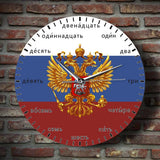 Horloge murale russe à quartz avec armoiries aigle à deux têtes et cadran aux chiffres en langue russe et couleur darpeau blanc,bleu,rouge sur le mur